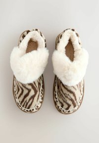 Papuci maro și crem cu un model de dungi de zebra, guler din blană sintetică pufoasă și cusături decorative în jurul talpă. Textură moale.
