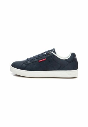 Zapatillas de piel azul marino con suela de goma blanca, punta redonda y detalles perforados. Presentan cordones planos y un pequeño acento de logo rojo.
