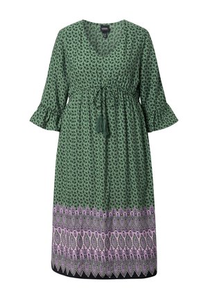 Vihreä midimekko, jossa pieni musta kukkakuvio, kellohihat, kiristysnyörivyötärö tupsuilla ja vaaleanpunainen kuvioitu reunus helmassa.