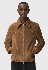 Ruskea mokkatakki, jossa on vetoketjullinen etusuljin, kaulus ja sivutaskut. Takissa on sileä pinta ja vartalonmyötäinen leikkaus.