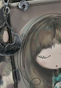 Borsa in pelle marrone con un'illustrazione di una ragazza, hardware metallico e un ciondolo argento con una perlina rosa. Tessuto con dettagli di cucitura.