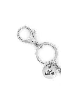 Portachiavi in metallo argentato con gancio a molla, anello circolare e un'etichetta rotonda incisa con "ΔX SUN68." Texture liscia, finitura lucida.