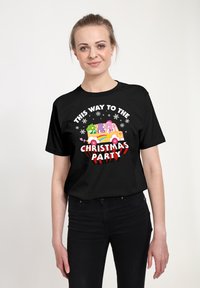 Sort bomulds t-shirt med farverig grafisk design og teksten "DENNE VEJ TIL JULEFESTEN," snefnug og en festlig køretøjsillustration.