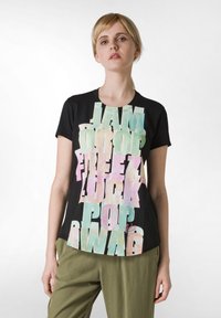 Černé tričko s barevným, nadměrným textovým designem, který obsahuje slova jako "JAM" a "SWAG", krátké rukávy a kulatý výstřih.