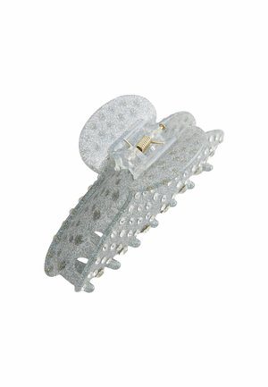 Kimallellinen hopeinen hiuskliippi, joka on valmistettu läpinäkyvästä materiaalista. Siinä on pyöreitä läpivientejä ja jousikorkki, joka takaa turvallisen kiinnityksen.