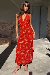 Červené květinové maxi šaty s hlubokým výstřihem do V, ve stylu na zavazování za krk, s lehkým materiálem, splývavým střihem a decentními květinovými vzory.