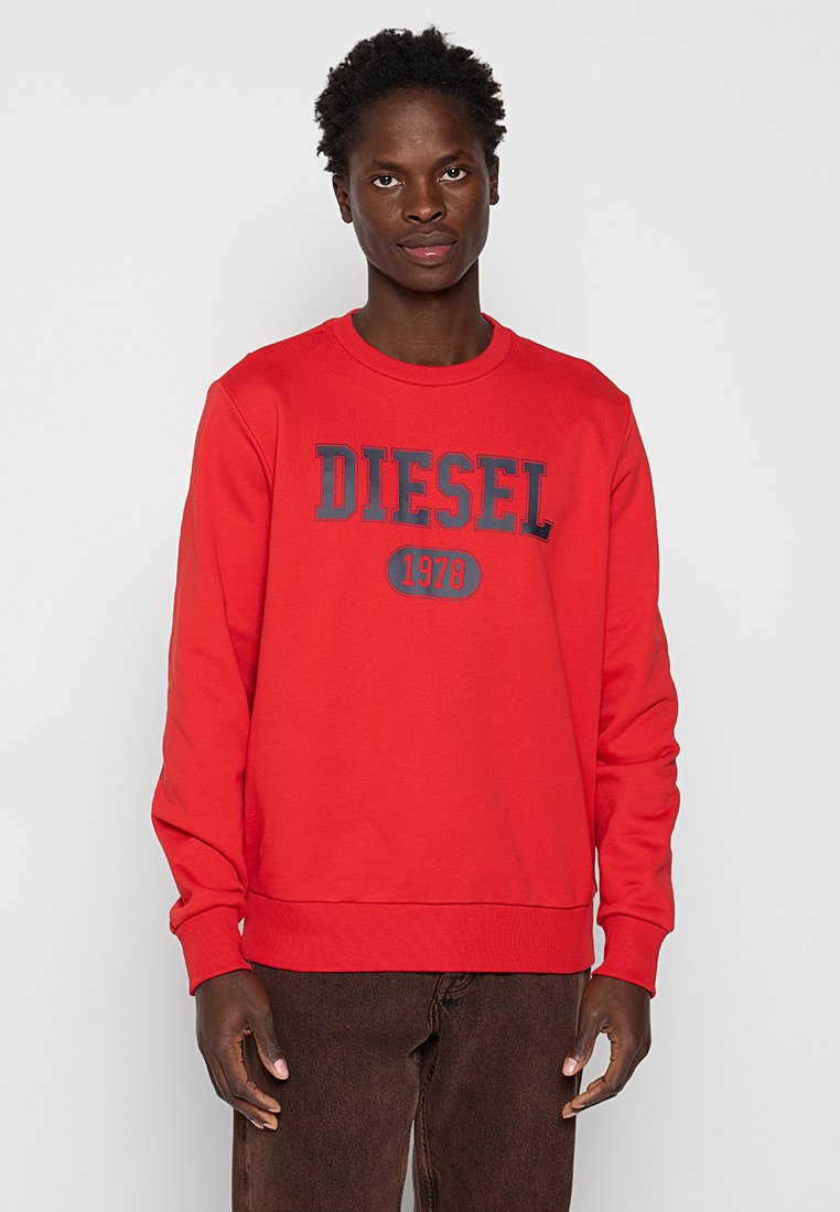 Felpa rossa in cotone con colletto a coste. Presenta il logo "DIESEL" e l'anno "1978" stampati in blu scuro sul davanti. Vestibilità classica.