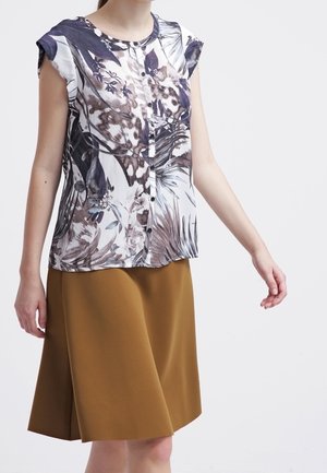Camicia a maniche corte con bottoni, a fantasia floreale, nei toni del bianco, blu e marrone, abbinata a una gonna marrone a lunghezza ginocchio. Tessuto dalla superficie liscia.