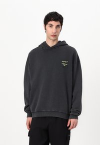 Gray oversized hoodie with a drawstring and ribbed cuffs. Features a neon green logo on the chest. Made of soft cotton material.