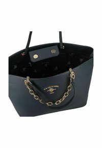 Černá taška z pebble kůže s zlatými řetězovými akcenty, která má vrchní uzávěr, vnitřní kapsu a logo na vnějším povrchu.