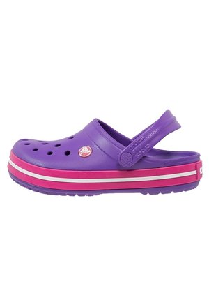 Purple Crocs clog with pink and white striped sole and adjustable heel strap on white background.