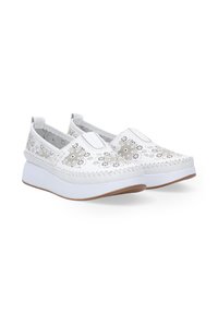 Witte instapschoenen met laser-geperforeerde bloemenpatronen, een textuur bovenwerk en een witte rubberen zool met een lichte hak.