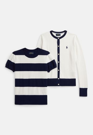 Granatowo-biała koszulka w paski z krótkim rękawem, zestawiona z granatowym kardiganem na guziki z długim rękawem, oba wykonane z miękkiej tkaniny.