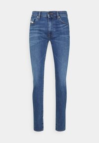 Vaqueros slim fit azul medio con cierre de botón y cremallera, bolsillos en la parte delantera y trasera, y detalles de desgaste sutil en los muslos.