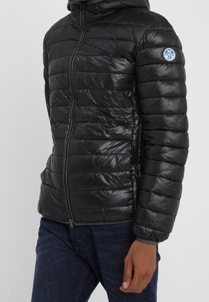 Doudoune noire avec un design matelassé horizontal, texture brillante, fermeture éclair et capuche. Présente un logo circulaire sur la manche gauche.