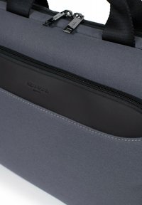 Grijze stoffen laptoptas met een glad zwart ritsvak. Voorzien van dubbele ritsen en duurzame textiele handvatten. Eenvoudig ontwerp en textuur.