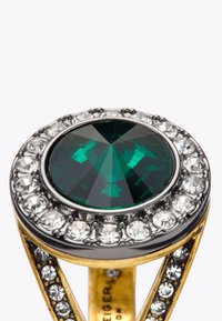 Bague en or ornée d'une grande pierre verte ronde entourée de cristaux transparents, avec un design de bande complexe mettant en valeur de petits cristaux supplémentaires.