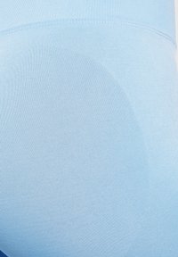 Jasnoniebieskie legginsy wykonane z elastycznego, prążkowanego materiału o gładkiej fakturze, z bezszwowym wykończeniem i dopasowanym krojem.