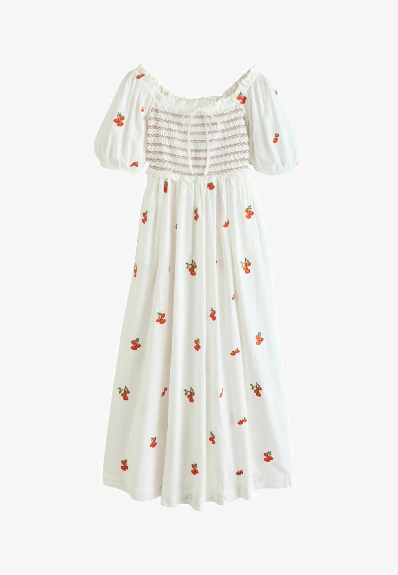 Robe blanche à épaules dénudées avec manches bouffantes, corsage froncé et imprimé de cerises rouges éparpillées sur le tissu.
