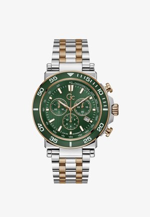 Chronograf s zeleným ciferníkem, stříbrným a zlatým nerezovým páskem a třemi subciferníky. Disponuje tučnými bílými hodinovými indexy a tachymetrickým bezel.