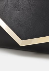 Black textured synthetic clutch with a gold geometric accent along the edge, featuring a sleek, angular design.