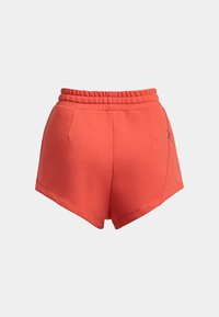 Pantaloni sportivi corallo con vita elasticizzata, dotati di tasche laterali e un logo a contrasto sul lato sinistro. Tessuto liscio e leggero.