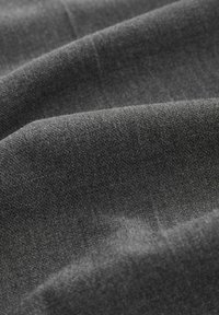 Dunkelgrauer Stoff mit einer glatten Textur, der subtile Variationen in der Schattierung und ein weiches, mattes Finish aufweist. Betont die Tiefe in den Falten.