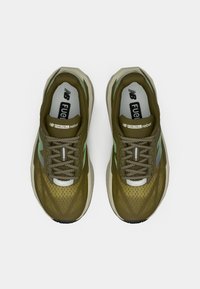 Zapatillas deportivas verdes con una parte superior de malla transpirable, acentos en verde claro en contraste, cuello acolchado y una suela acolchada.