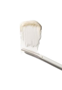 Peigne blanc avec des dents fines et larges, partiellement recouvert d'une substance crémeuse, posé sur un fond blanc uni.