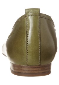 Green leather flat shoe with a rounded toe and low wooden heel. Features visible stitching along the back and a smooth, glossy finish.