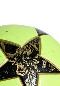 Spilgti zaļš futbola bumba ar teksturētu virsmu, melna un zelta zvaigžņu dizains, kura centrā ir vērša galva.