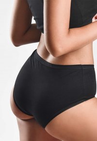Slip neri a vita alta realizzati in tessuto morbido, con un design senza cuciture e un elastico alla vita per il massimo comfort.