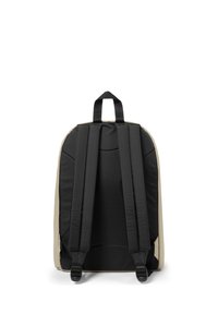 Musta ja beige reppu, jossa on pehmustetut olkahihnat, litteä selkä ja ylhäällä oleva kantokahva. Materiaali on sileä ja muotoilu on yksinkertainen ja toiminnallinen.