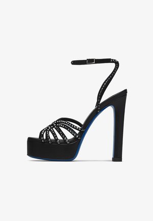 Schwarze Plateau-Sandale mit genietetem Riemen-Obermaterial und Knöchelriemen mit Schnalle, mit blauem Sohlen-Detail.