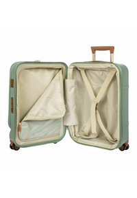 Harde koffer in muntgroen, met een beige interieur, verstelbare riemen en een ritsvak voor organisatie.