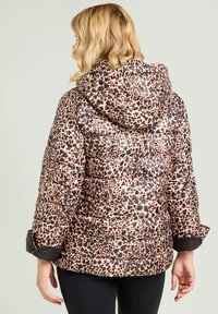 Chaqueta acolchada con estampado de leopardo que incluye una capucha, detalles en negro y textura acolchada. El fondo es de un color claro neutro.