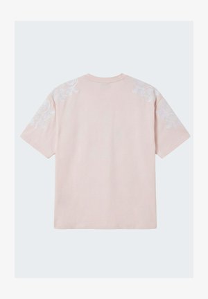 Camicia rosa chiaro a maniche corte con ricamo floreale bianco sulle spalle e sulla parte superiore delle maniche, vista da dietro.