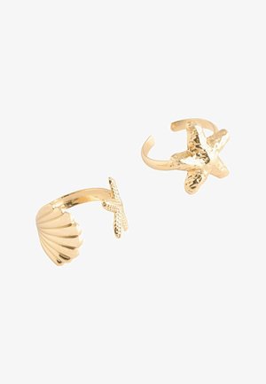 Two gold-tone adjustable rings, one with a shell design and the other with a textured starfish motif, on a white background.