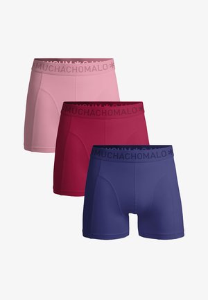 Tri páry boxeriek v ružovej, červenej a modrej farbe, každé s pásom označeným nápisom "MUCHACHOMALO".