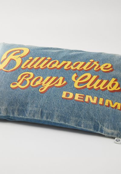 Denimist padja, mille peal on bold kollastes ja punastes tähekirjas "Billionaire Boys Club" ja "DENIM", millele lisab särtsu tekstureeritud sinine kangas.