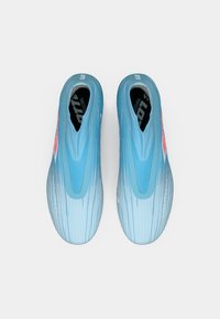 Et par lyseblå slip-on sportsko med subtil gradientdesign og pink logo på innsiden, sett ovenfra mot hvit bakgrunn.