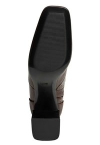 Suela de zapato de cuero marrón con un tacón cuadrado negro, con superficies texturizadas para mayor agarre y un contorno suave y curvado.