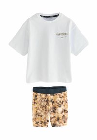 Valkoinen puuvillapaita, jossa on kultainen "ALLSAINTS"-logo rintamassa, yhdistettynä leopardikuosisiiin shortseihin, joissa on musta vyötärönauha.