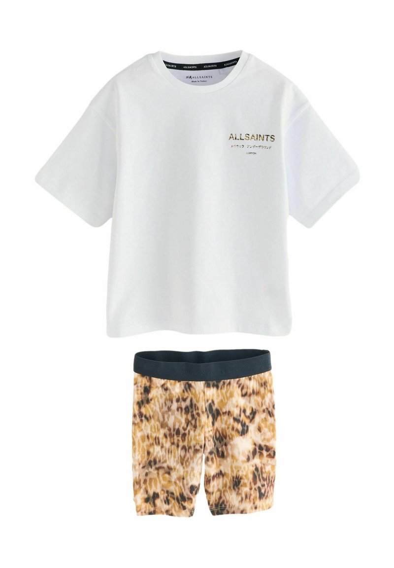 Valkoinen puuvillapaita, jossa on kultainen "ALLSAINTS"-logo rintamassa, yhdistettynä leopardikuosisiiin shortseihin, joissa on musta vyötärönauha.