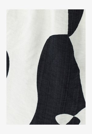 Black and white fabric showcasing large, abstract shapes. The texture appears woven, with a subtle sheen and a slightly crinkled surface.