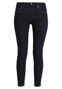 Jeans ajustados de color azul oscuro, fabricados en denim con una textura suave, que cuentan con cinco bolsillos, cierre de botón y costuras amarillas en contraste.