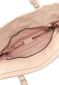 Wnętrze jasnoróżowej skórzanej torebki z gładką teksturą, wyposażone w zapinaną na zamek kieszeń oraz główną komorę z miękką podszewką.