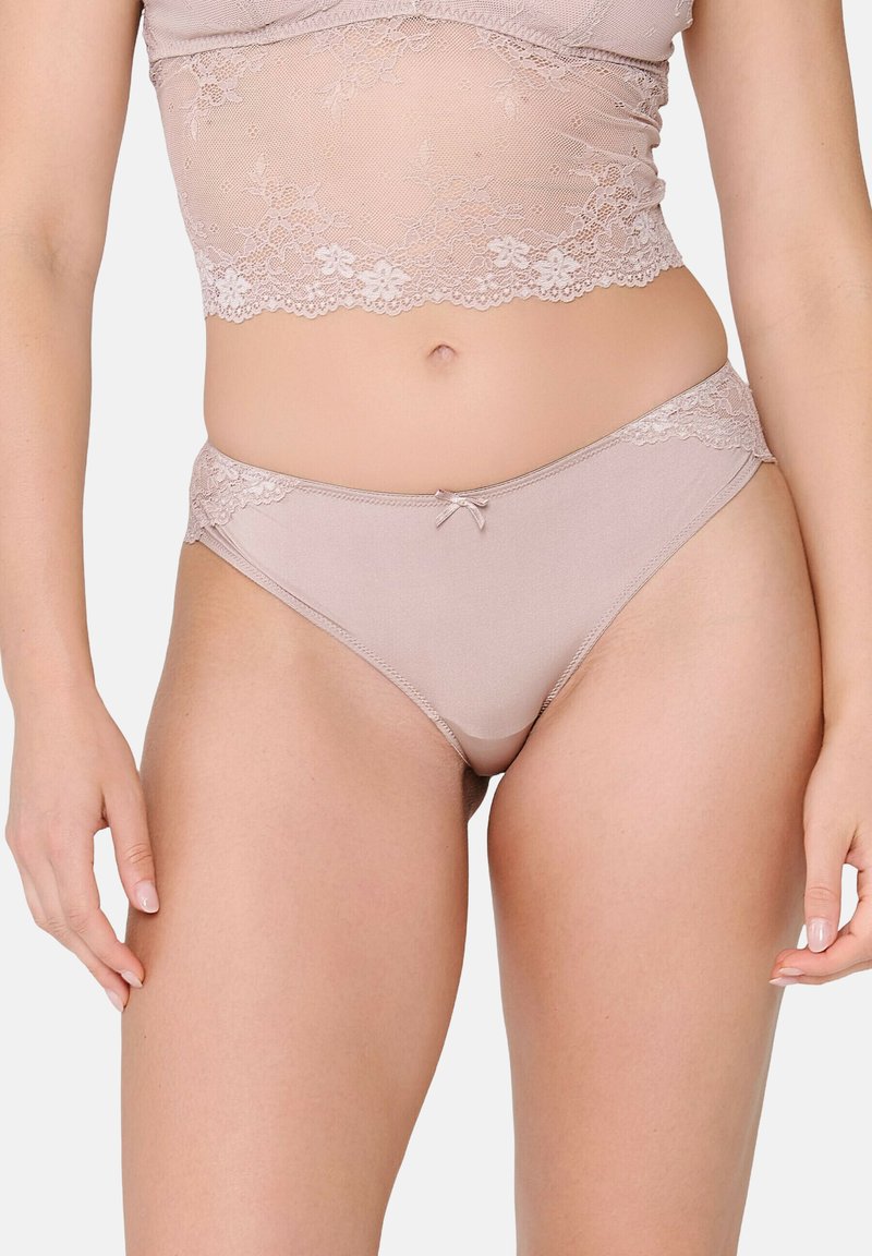 Slip in pizzo color nude con un morbido tessuto, caratterizzati da un fiocco decorativo sul davanti e aperture alte sulla gamba per un fit comodo.