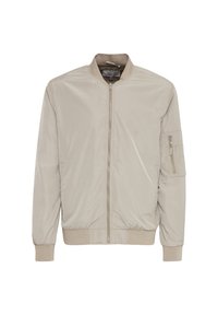 Blouson aviateur beige clair avec fermeture éclair à l'avant, col, poignets et ourlet côtelés, et une poche zippée sur la manche gauche.