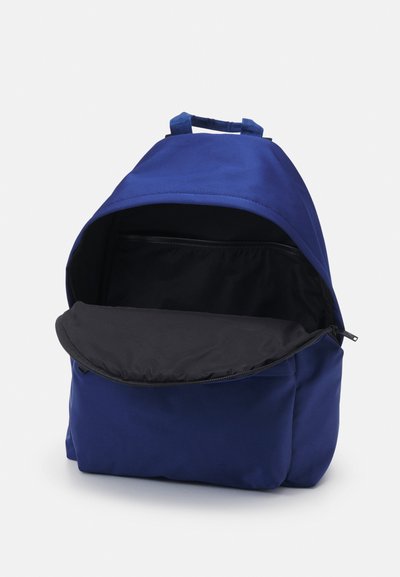 Blå nylonryggsäck med rundad form, zip-försedd öppning upptill och en svart inre ficka. Har ett handtag upptill för bärande.